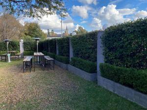 a fence with tables and chairs in a garden at Australian Hotel Young in Young