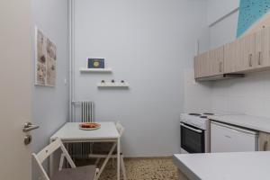 a small white kitchen with a table and a small table with a bowl of food at Kerameikos Metro Apartment for 4 in Athens