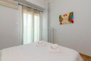 a bedroom with a white bed with two towels on it at Kerameikos Metro Apartment for 4 in Athens