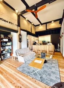 a living room with a couch and a table at 古民家グランピングMatoba in Miyoshi