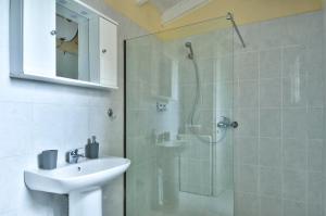 une salle de bain avec douche, lavabo et toilettes dans l'établissement Villa Serena, à Nisakion 26 autres photos