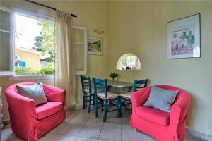 une salle à manger avec des chaises roses et une table dans l'établissement Villa Serena, à Nisakion