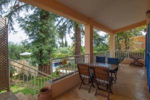 a porch with a table and chairs and trees at Villa Serena in Nisakion