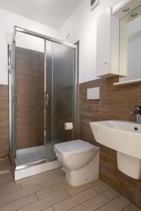 a bathroom with a shower and a toilet and a sink at La Suite sul Borgo in Fregene