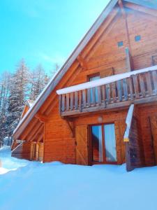 a log cabin in the snow with a balcony at Le petit chalet Les Flocons du soleil in Le Dévoluy