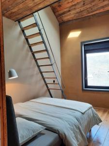 a bedroom with a bed and a stair case at Gîte l'Atelier agréable maison de ville avec cour intérieure in Saint-Hubert