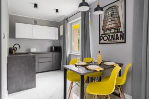 kuchnia ze stołem i żółtymi krzesłami w obiekcie Chociszewskiego Apartment Poznań by Noclegi Renters w Poznaniu