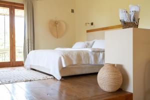 a bedroom with a bed and a vase on the floor at Hanahala Beramot - Boutique Suites in Moshav Ramot