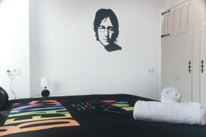 Schlafzimmer mit einem Bett mit Wandgemälde in der Unterkunft CASA BEATLES DEL VALLE in Pinos del Valle