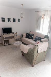 Una sala de estar con un sofá y un televisor. en CASA BEATLES DEL VALLE, en Pinos del Valle