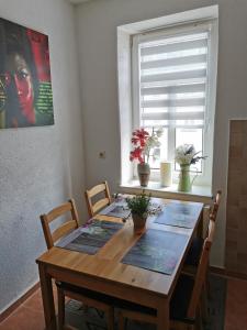 einen Esstisch mit Stühlen und ein Fenster in der Unterkunft Ferienwohnung Anger 1 im 3 Obergeschoß in Annaberg-Buchholz