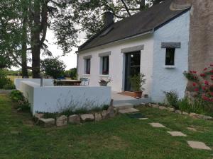 una casa blanca con una valla blanca en el patio en Le moulin de La Retardière, en Orvault