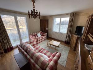 a living room with two couches and a table at maison du haut de FREYDON ambiance Montagne in Allevard