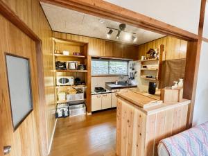 a large kitchen with wooden walls and wooden floors at 古民家ステイMatoba in Miyoshi