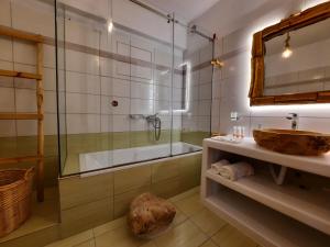 e bagno con doccia, lavandino e vasca. di Janakos View Apartment with Private Pool a Glinado Naxos