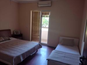 a bedroom with two beds and a sliding glass door at Shale apartments and rooms in Gevgelija