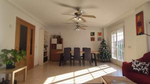 een woonkamer met een tafel en een kerstboom bij Warner,piscina, aire ac, barbacoa, chillout, 400m patio in Seseña