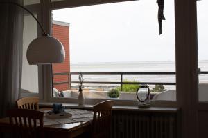 a dining room table with a view of the ocean at Oland Whg 23 Küstensegler in Wyk auf Föhr