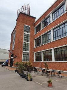 un edificio de ladrillo con mesas y sillas delante de él en Hotel / Restaurante LA PEPA, en Avilés