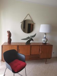a mirror on top of a wooden dresser with a chair at Ria´s Relax in Alvor