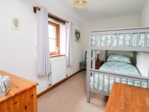 ein Schlafzimmer mit einem Etagenbett und einem Schreibtisch in der Unterkunft Lavender Cottage in Penrith