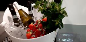 um balde cheio de garrafas de champanhe e morangos em Continental Urban Art Hotel em Zola Predosa