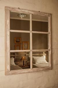 a window on a wall with a lamp and pillows at Kalkfontein Guesthouse in Merweville