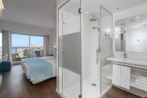 a bathroom with a shower and a bed and a sink at Alua Leo in Can Pastilla