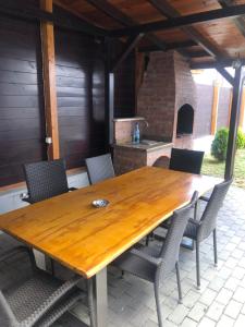 a wooden table and chairs on a patio with a fireplace at Deluxe Villa with BBQ in Şelimbăr