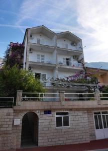 ein Gebäude mit Blumen auf einer Ziegelmauer in der Unterkunft Apartman Nikolić 1 in Makarska