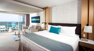 a hotel room with a large bed and a large window at Sonesta Ocean Point Resort- All Inclusive - Adults Only in Maho Reef