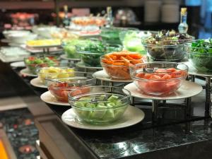 a buffet line with bowls of vegetables on plates at Holiday Inn Bursa - City Centre by IHG in Bursa
