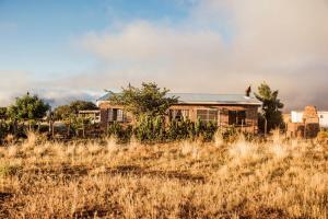 an old house in the middle of a field at Kalkfontein Guesthouse in Merweville