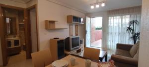 salon z kanapą i telewizorem w obiekcie ACV - Playa Coral II-2ªlinea planta baja norte w mieście Oropesa del Mar