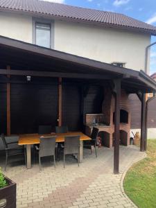 a pavilion with a wooden table and chairs on a patio at Deluxe Villa with BBQ in Şelimbăr