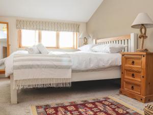 a bedroom with a large bed and a window at Maple in Falmouth