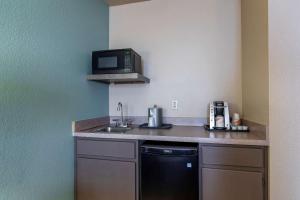 a kitchen counter with a microwave and a cupboard at Comfort Inn & Suites Boulder North in Boulder