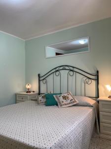 una camera da letto con un letto con copriletto bianco di Attico a San Vito Lo Capo a San Vito lo Capo