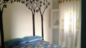 una camera con letto con testiera di albero di Le Vallonee B&B ad Aradeo