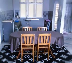 a kitchen with a table with four chairs around it at Cocobay Resort Cosy Apartment in Kampong Tanah Merah