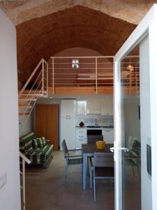 eine Küche und ein Esszimmer mit einer Treppe in einem Haus in der Unterkunft Liama Macchia degli Specolizzi in Lido Marini