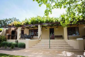 a house with a staircase in front of it at Skilpadvlei Wine Farm in Stellenbosch