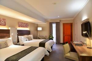 Cette chambre comprend deux lits et un bureau. dans l'établissement Birchwood Hotel and OR Tambo Conference Centre, à Boksburg