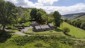 an aerial view of an old house in a green field at Snowdonia Holiday Cottage in Bala