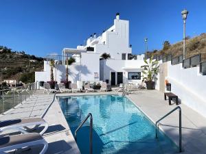 a swimming pool in front of a white building at Balcon del Mar Seaview 113 Casasol in Nerja