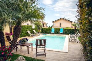 a swimming pool with chairs and a table next to a house at Casa vacanze ETNA COCUS in Santa Venerina
