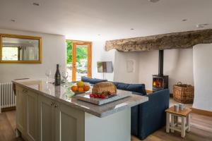 a kitchen and living room with a counter and a fireplace at Snowdonia Holiday Cottage in Bala
