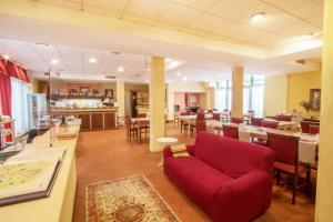 a living room with a red couch and a restaurant at Residence Mugello Resort in Scarperia