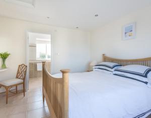 a bedroom with a large bed and a chair at Polmorla in Polzeath