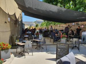 a group of people sitting at tables in a patio at L'Escale de la Gare in Saumur